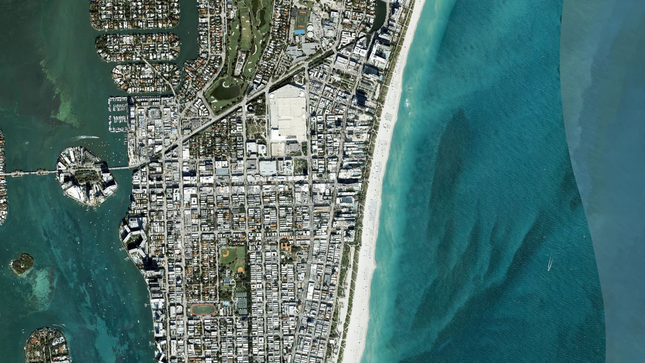 Aerial satellite view of the Miami Beach coastline: the barrier island, turquoise Atlantic, and the bay